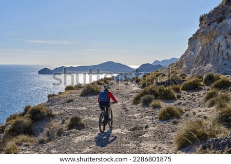 nice senior woman cycling with her electric mountain bike in the volcanic nature park of Cabo de Gata, Costa del Sol, Andalucia Royalty-Free Stock Photo #2286801875