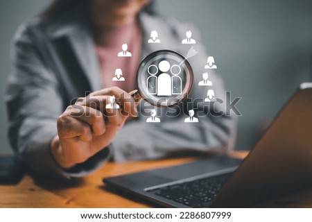 Businessman use magnifying glass to find human icon for business CRM or Customer Relation Management and customer focus target group concept, social media. Digital marketing online. HRM, human manage.