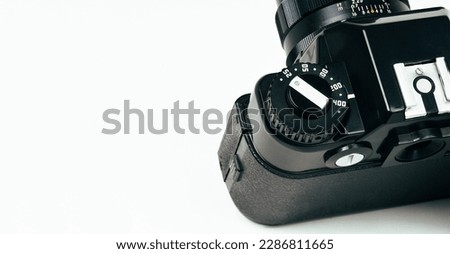 Close up of vintage film camera dial iso selector on white background with copy space.