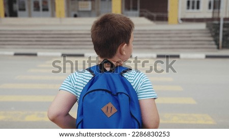 portrait child boy running through crosswalk road. happy teenager child with backpack runs school. satisfied first grader rules road. running road. security concept. zebra pedestrians. safe passage.