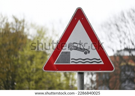 Traffic sign indicates the danger of falling on a bank
