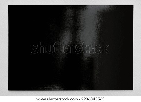 single empty dark shiny Photopaper piece on white background, nice photo or poster overlay. Royalty-Free Stock Photo #2286843563