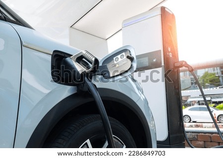 Electric car in EV charging station, concept of green energy and eco power produced from sustainable source to supply to charger station in order to reduce CO2 emission. Royalty-Free Stock Photo #2286849703