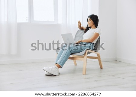 Woman relaxing at home and sipping her hands sitting in a chair with her laptop, lifestyle homemade spirits. Mockup, free copy space