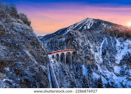Landscape of Train passing through famous mountain in Filisur, Switzerland. Landwasser Viaduct world heritage with train express in Swiss Alps snow winter scenery.  Royalty-Free Stock Photo #2286876927