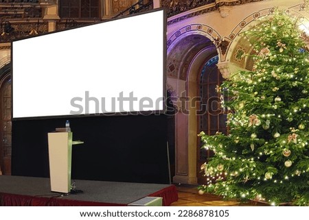 Large empty video projector screen with white blank screen mockup near the Christmas tree