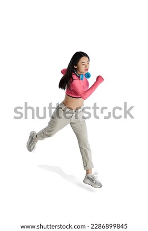 Top isometric view. Young girl with headphones in casual clothes in motion, running isolated over white background. Concept of business, employment, education. lifestyle. Copy space for ad Royalty-Free Stock Photo #2286899845