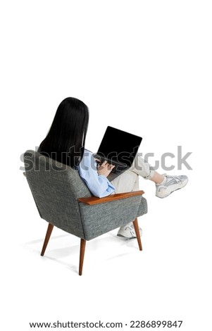 Top isometric back view. Young girl in shirt sitting on chair and working, studying in laptop isolated over white background. Concept of business, employment, education. lifestyle. Copy space for ad Royalty-Free Stock Photo #2286899847