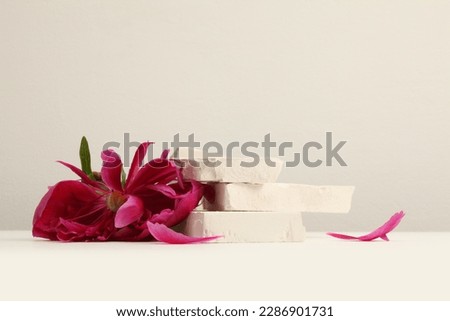 Flower pink petal and empty stones platform podium on beige background. Minimal display product presentation scene.