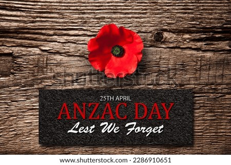 The remembrance poppy - poppy appeal. Poppy flower on old wooden background with text. Decorative flower for Anzac Day in New Zealand, Australia, Canada and Great Britain.