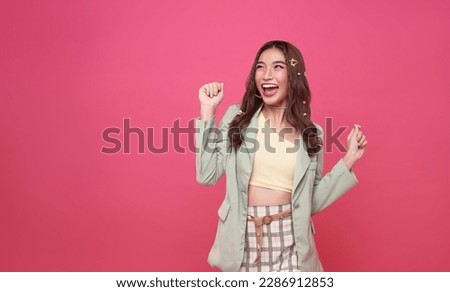 Excited asian teen woman with raised hands celebrating success Portrait cheerful positive asian woman with raised hands and fists open mouth Girl get happy, enjoy life isolated on pink copy space