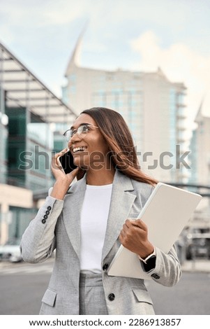 Vertical portrait of successful African American business woman having phone call outdoor. Middle age businesswoman in suit talking on smartphone, standing at city urban street business office center. Royalty-Free Stock Photo #2286913857