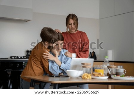Loving children supporting hugging single mother struggling to find job. Upset unhappy family mom and two kids embracing looking at laptop screen. Son and daughter support upset mum lost job Royalty-Free Stock Photo #2286936629