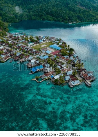 an aerial shot of a village by the sea, located in Banggai Kepulauan, Central Sulawesi, Indonesia 