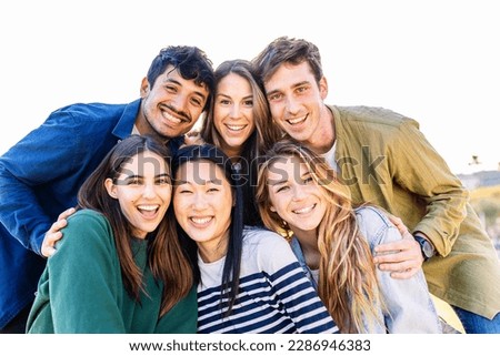 Happy group of young friends smiling at camera outdoors. Multiracial people having fun together.