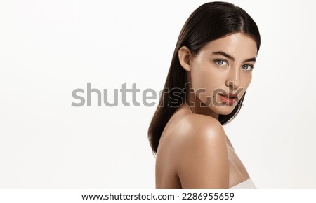 Gorgeous brunette woman with blue eyes, clear glowing skin, perfect shiny body after spa effect, doing nourishing skincare routine, spa at home, standing over white background. Royalty-Free Stock Photo #2286955659