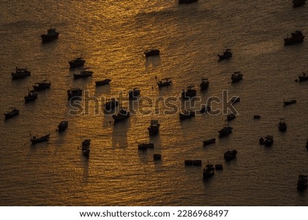 Top view, aerial view wooden fishing boat on the beach from a drone. Royalty high quality stock photo image of the wooden fishing boat on the beach. Fishing boat on cinematic sunset.