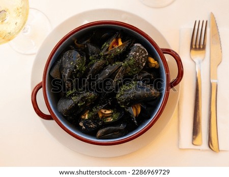 Picture of steamed tasty mussels served on pan with lemon, tapas of spanish cuisine