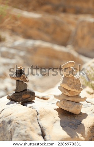 Pyramid stones balance on the sand rock. The object is in focus, the background is blurred