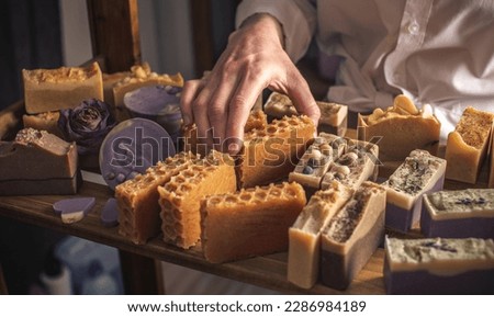 A woman master soap maker holds handmade honey soap in her hands. Eco-friendly natural craft cosmetics production Royalty-Free Stock Photo #2286984189