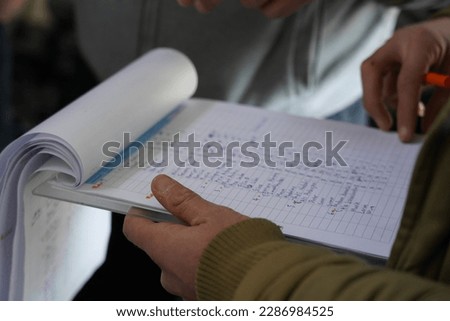 a man was checking a list of names in an open notebook Royalty-Free Stock Photo #2286984525