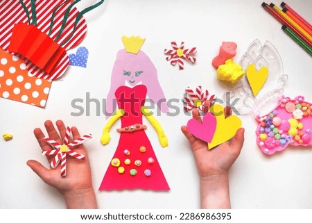 Child creating homemade greeting card with princess. Gift for Mothers day, Birthday or Valentines day . Arts crafts concept. Preschool crafts. Project of children's creativity