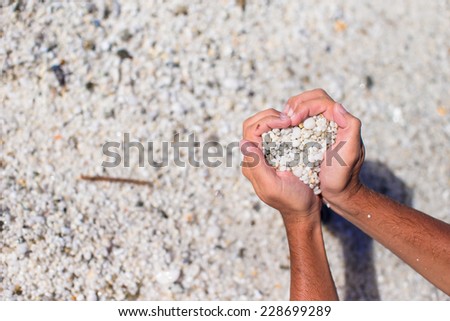Hands in the form of heart with pebbles inside