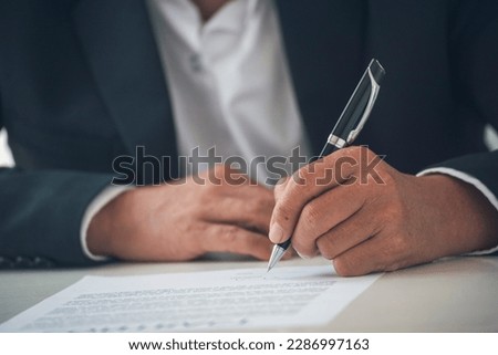 Businessman hand using pen signing on new contract starting projects in conference room. Close up business manager man hands sign contract legal document in meeting room. Business agreement concept