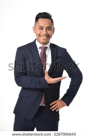 Portrait of young business man in black suit,tie with welcome gesture 