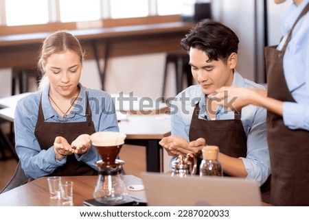 Young man and woman learning making coffee and sniff bean with barista while laptop on desk at cafe, group people training drip coffee with entrepreneur, small business or SME. Royalty-Free Stock Photo #2287020033