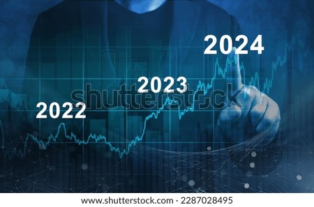 economic recovery after falling due to inflation, stagnation, recession, 2024 financial chart. Businessman pointing graph of future growth on dark blue background Royalty-Free Stock Photo #2287028495