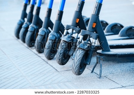 Electric scooters are parked in the city center. Public mobile transport stand outside Royalty-Free Stock Photo #2287033325