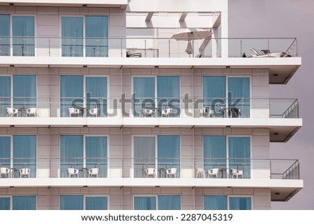 Plastic chairs on the balconies of a multi-storey building.