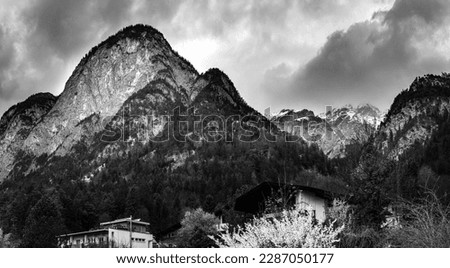 High mountains of the Alps of Nordkette, also called the North Chain or Northern Range in Innsbruck, Tyrol, Austria, dramatic black and white cloudscape with rain in the springtime