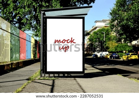 blank lightbox and glass bus shelter at bus stop. soft urban street background. white ad poster, commercial space. display panel. empty outdoor ad space. mockup base. parked cars. blurred background.