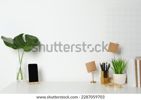 Comfortable workplace with white desk near wall. Space for text Royalty-Free Stock Photo #2287059703