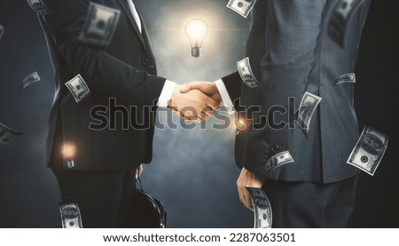 Side view and close up of businesspeople shaking hands with blurry flying dollar bills on chalkboard wall background. Finance, success and casino concept