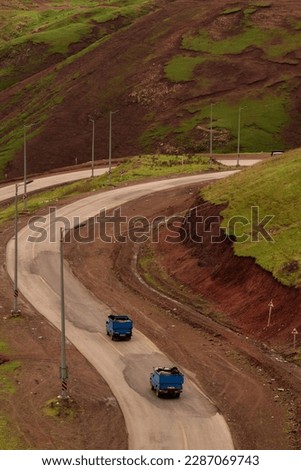 Two cars passing through a winding road in Gilan