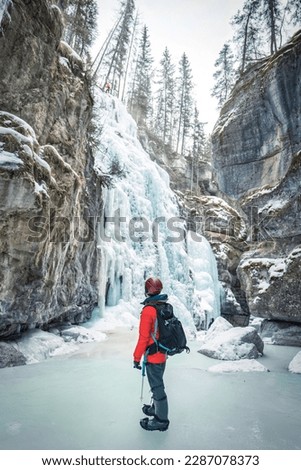 Mountaineer man standing in Maligne Canyon with frozen waterfall at Jasper national park, AB, Canada Royalty-Free Stock Photo #2287078373