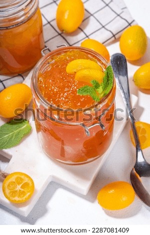 Kumquat jam, homemade citrus tropical fruit marmalade, with fresh kumquat on a white marble table Royalty-Free Stock Photo #2287081409