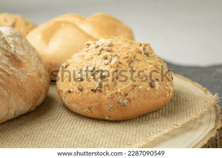 Fresh and crispy bread dissolves on the towel. Close-up of whole fresh crispy tasty wheat bread. Side view