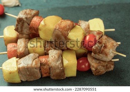 A dish of meat with potatoes and vegetables. Delicious and appetizing, Cooked barbecue on skewers. Shish kebab with vegetables. Place for text