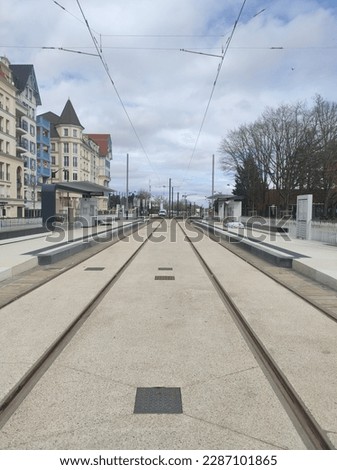Tram line in the middle of rural or urban area, with colorful housing and new houses, under maintenance, nobody and empty, railway destination and means of transport