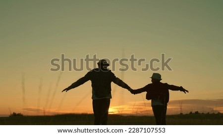 Father, child son run together holding hands, sunset. Kid dad travel in park, happy family. Silhouette. Dad plays with his kid outdoors, walk in park. Childhood dream, fatherly. Child, Dad, fly Sky