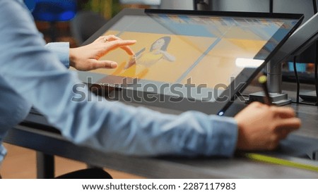 Asian professional artist editing pictures with graphic tablet and stylus, using retouching software for photo production. Young editor working on multimedia content with skills. Close up.