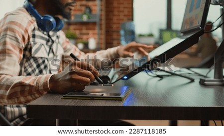 Male photographer working on image editing with retouching software, using tablet and stylus to create media production at creative agency. Artist creating picture edit with color grading.
