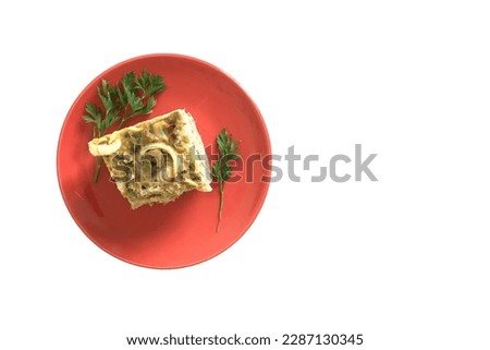 Homemade cod pie with palm heart and olive on a ceramic plate isolated on a white background and copy space. Torta capixaba