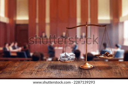 striking image of a scale tipping on courtroom in favor of a pile of bills heavier than a judge's hammer is a reflection of our societal obsession with money and material wealth. Royalty-Free Stock Photo #2287139293