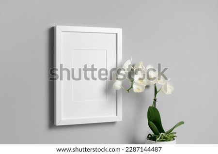 White picture frame mockup with orchid flower, blank poster frame mockup with copy space