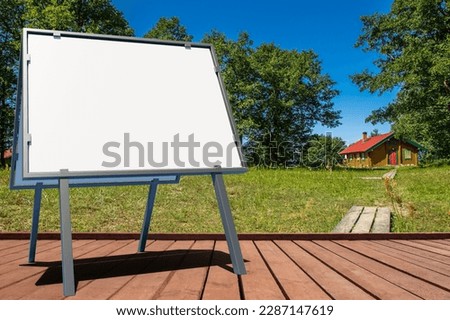 Empty signboard. Advertising sign on terrace. Place for announcement. Signboard on territory of eco hotel. Portable billboard template. Signboard mock up. Rural area. Country real estate. 